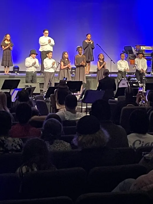 Students performing on stage during the school musical production